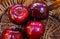 Close up of  four red dotted shiny isolated dessert apples in wicker reed basket