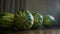 Close up of four whole watermelons on a wooden brown table indoors. Video. Summer vitamins, ripe berries in the kitchen