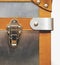 Close-up fragment of locks and fasteners on the vintage leather and metal suitcase brown, vertical image