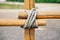 Close-up fragment of wooden fence. Wooden logs tied with strong rope.