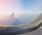 Close up frame of plane window seeing ice crystals in foreground and aircraft`s wing and horizon in background