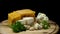 Close up for french delicious aged cheeses choped and served on wooden board isolated on black background. Frame