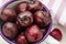 Close-up of fresh cherries in white porcelain cup. On pink fushia background.
