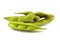 Close-up of fresh cooked soybean pods with salt and partially opened, isolated against white background