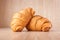 Close up of fresh delicious croissants on wooden background