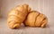 Close up of fresh delicious croissants on wooden background