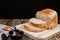 Close up fresh homemade loafs bread and sliced bread on cutting board with jam strawberry on wooden background