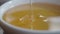 close up of fresh honey pouring in a bowl