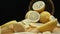 Close up of fresh lemon slices are arranged against a rustic basket. Comestible.