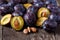 Close up fresh plums over wooden table background