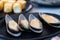 Close up of fresh raw green mussel on black plate