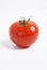 Close-up of fresh red tomato with water droplets over white background