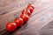 A close-up of fresh red tomatoes. Colorful tomatoes on a wooden background. Organic salads ingredients. Red cherry tomatoes.