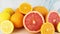 Close up of fresh sliced citrus fruits on cutting board on blue background