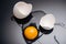 Close up of fresh smashed chicken egg with yolk, protein and eggshell on black background.