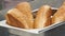 Close up of freshly baked bread buns inside metal metal container. Stock footage. Tasty soft bread for making sandwiches