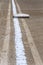 Close up of freshly chalked baseline, with base plate, dirt only, empty baseball field on a sunny day