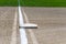 Close up of freshly chalked baseline, with base plate, dirt and grass, empty baseball field on a sunny day