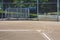 Close up of freshly chalked baseline leading to home plate, with backstop and bleachers, empty baseball field on a sunny day