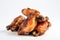 Close-up of fried chicken wings with a crust on a white background. Generative ai