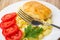 Close up of fried cutlet, pasta, slices of tomato