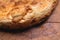 Close-up fried khachapuri cooked in the oven lies on a wooden board