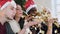 Close-up. Friends of different races blowing golden confetti from hands wearing christmas hat. Christmas and New Year