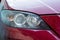 Close-up front headlight with xenon light of red modern car