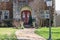 Close-up of front of house with beautiful flowers on double doors n early springtime with frisky squirrel running up the sidewalk