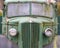 a close up of the front of an old abandoned Austin Commercial LC3 rusting green truck covered in moss. The LC series was built in