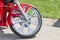 Close-up front part of retro custom motorcycle. Shining chrome vintage bike wheel with red fender