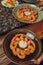 Close up front view of a fried bread coated shrimp, selective focus on single piece in chopsticks, with fresh garnishes.