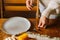 Close-up front view hands of unrecognizable young woman serving tableware waiting for friends to have dinner Christmas