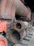 Close up front view of an old abandoned rusting steam locomotive with wrecked cylinders on railway tracks