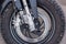 A close-up of the front wheel of a motorcycle with brakes