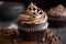 close-up of frosted chocolate cupcake with swirls and mini chocolate chips