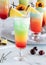 Close up of a frosty fruity mocktail garnished with a pineapple wedge with other mocktails in behind.