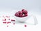 Close up of frozen rasberries in a white bowl on a white background with selective focus.