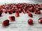 Close-up of fruit, seeds of ripe juicy pomegranate scattered on an abstract wooden surface.