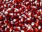 Close-up of fruit, seeds of ripe juicy pomegranate scattered on an abstract wooden surface.