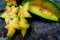 Close up of fruit star Averrhoa carambola on the black stone. Top view close up details.