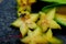 Close up of fruit star Averrhoa carambola on the black stone. Top view close up details.