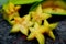 Close up of fruit star Averrhoa carambola on the black stone. Top view close up details.