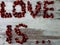 Close-up of fruits with blur / bokeh effect, pomegranate seeds laid out in words symbolizing love.