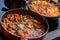 Close-up of frying pans with seafood dish cooked in tomato sauce. Fresh stewed Clams, Shrimps, mussels and squid, base