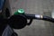 Close up fueling gun in a dark car gas tank