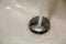 Close-up of full stream of clean transparent shiny water flowing splashing down the hole in kitchen ceramic white sink or shower c