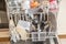 Close up of a fully stocked dishwasher in a kitchen with dishes glasses bowls knives forks spoons cutlery, Germany