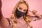 Close up fun young woman in pink blouse face, mask to safe from coronavirus virus covid-19 during pandemic quarantine doing selfie