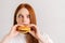 Close-up of funny fooling around young woman with strabismus pleasing bite of appetizing delicious burger looking at